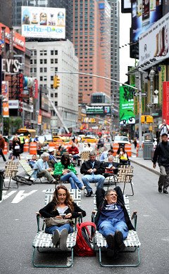 Pedestrians on Broadway enjoying lounge chairs and space as Times Square is converted into a pedestrian zone prohibiting vehicles.