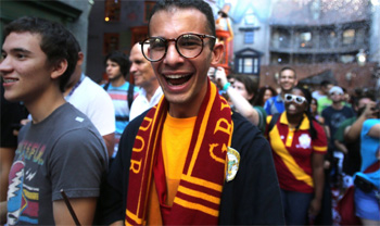 Harry Potter fan with glasses and Gryffindor scarf at the Wizarding World of Harry Potter in Orlando